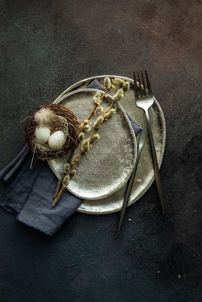 Top view of decorative egg in delicate nest on ceramic plate with space for text