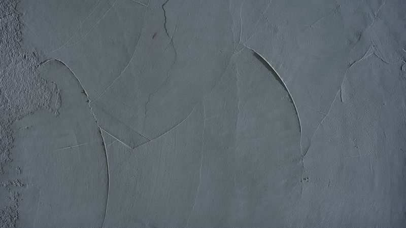 Smooth pale blue concrete wall with plaster texture and subtle surface cracks