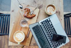 Table top photo of apple crumble pie dessert, sweet treat, coffee cups with latte art and pc