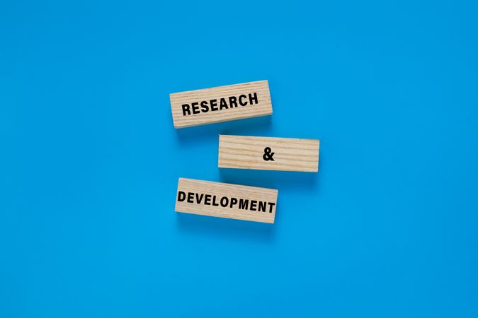 research and development words symbol on wooden blocks. isolated on blue background