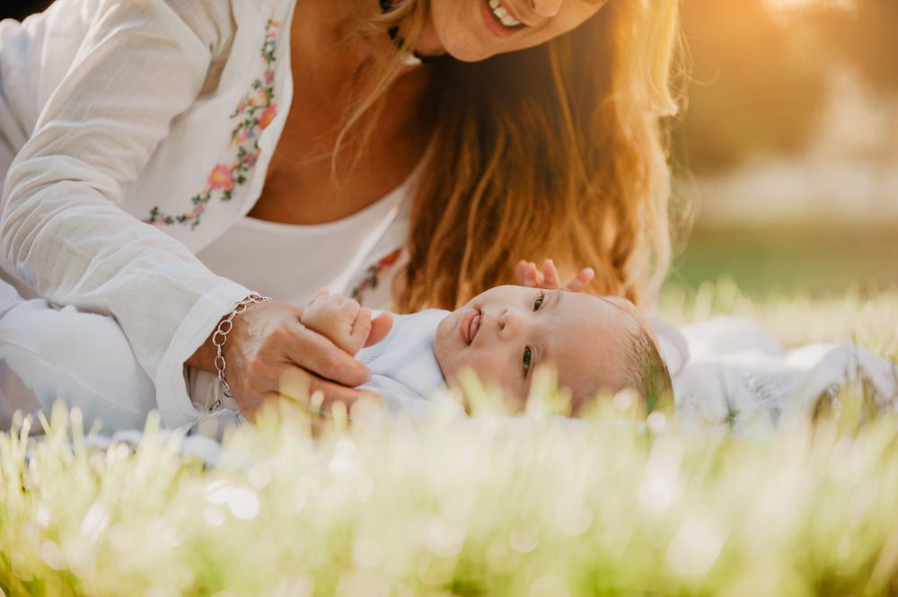 baby with down syndrome lying on a blanket with her grandmother