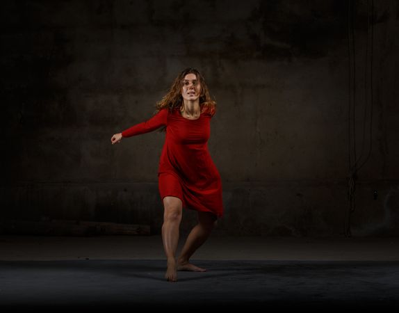 Young woman dancing in darkness