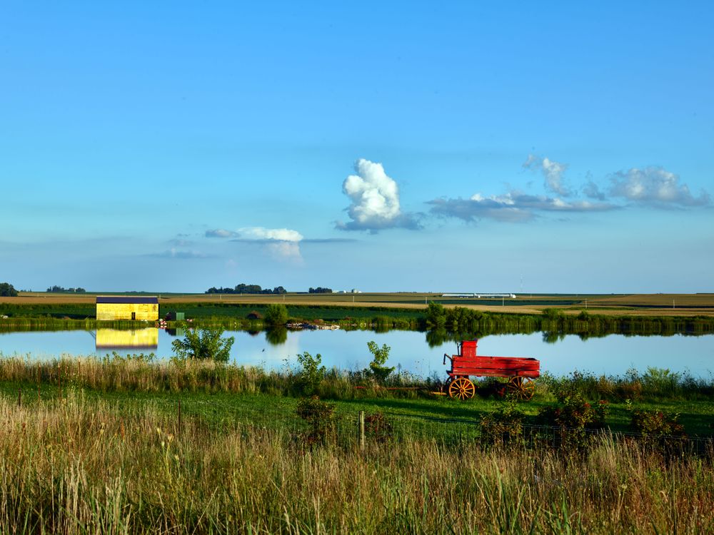 A bright-red freight wagon and bright-yellow cabin,  near the town of Dike, Iowa