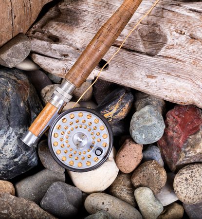 Vintage fly fishing outfit on rocks and wood