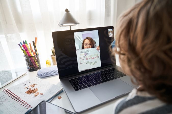 Anonymous boy doing homework with girl via laptop