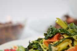 Plate of cooked greens side dish on table with space for text