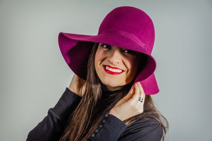 Woman with garnet hat over gray background
