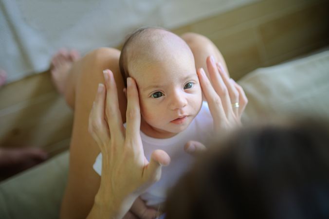 Mother caressing infant on sofa