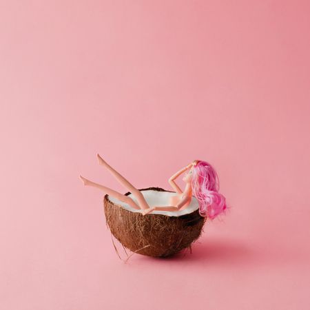 Doll with pink hair bathing in coconut