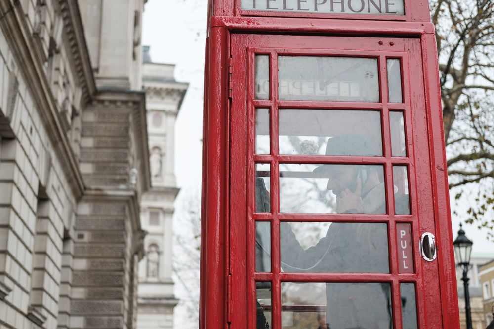 Red telephone box on autumn street