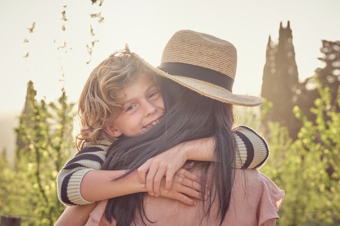 Happy son with mother on sunny day