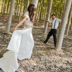 Newlywed husband and wife having fun together among trees