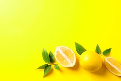 Flat lay composition with lemons on color background, space for text