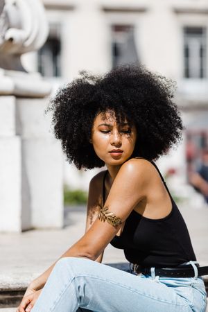 Black female siting on stairs outdoors