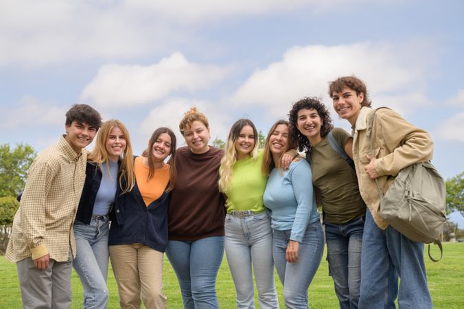 Happy multiethnic groupmates smiling and looking at camera in park