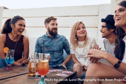 Group of friends relaxing together around a table 4A7e80
