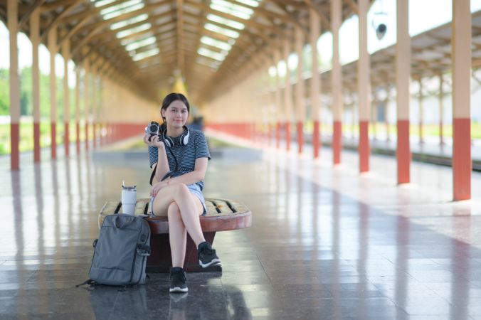 Female tourist waiting for the train on the platform to travel