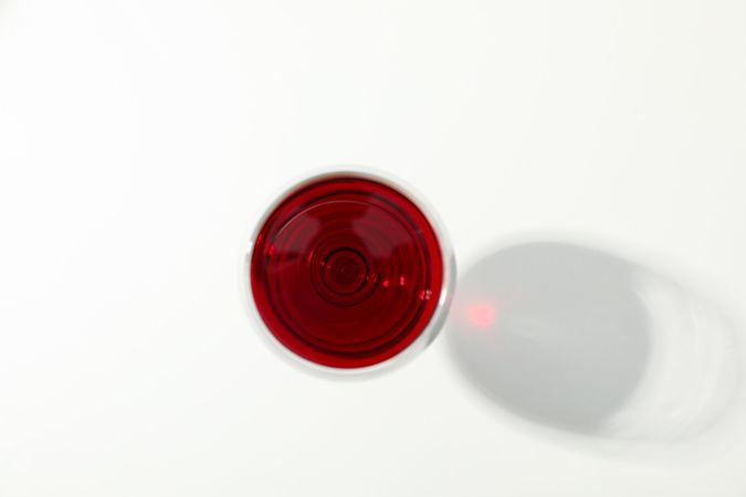 Glass with red wine on blank background, top view