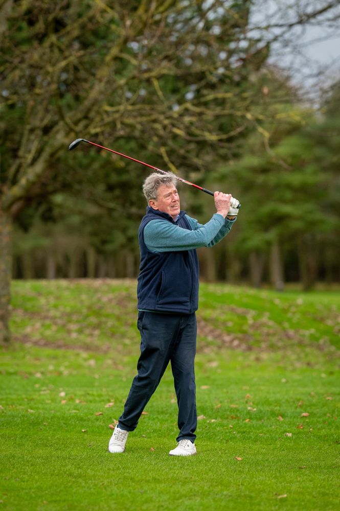 Man finishing swing on golf course