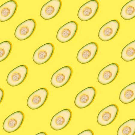 Cut avocado pattern on yellow background