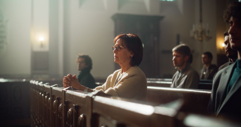 Group Of Faithful Parishioners In Grand Old Church Listening to Sermon.