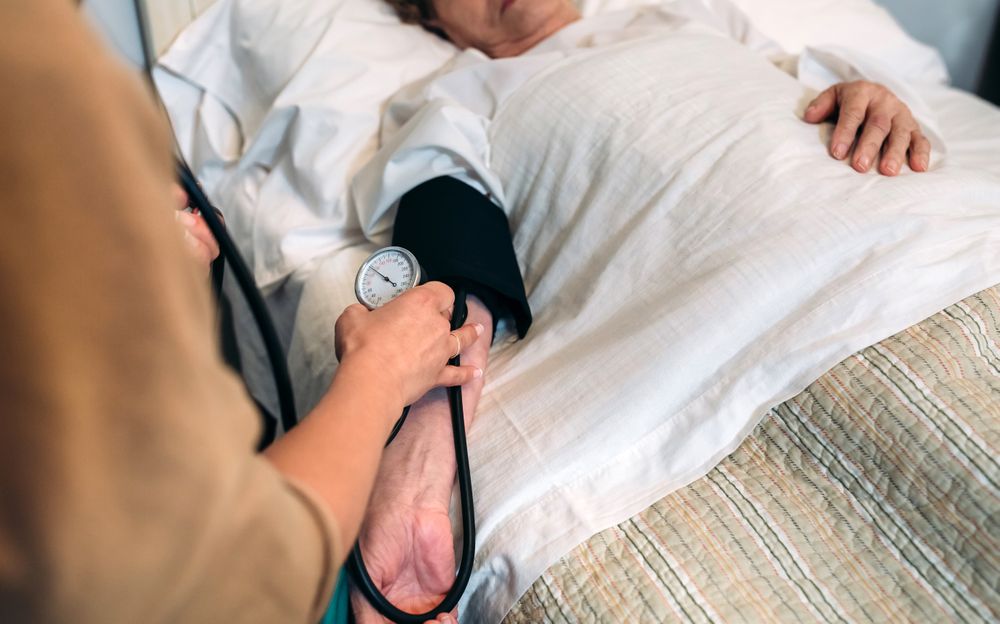 Caregiver checking blood pressure to a woman