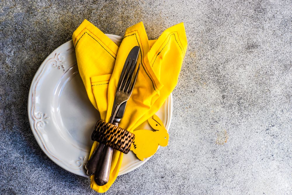 Easter table setting on concrete background with yellow napkin