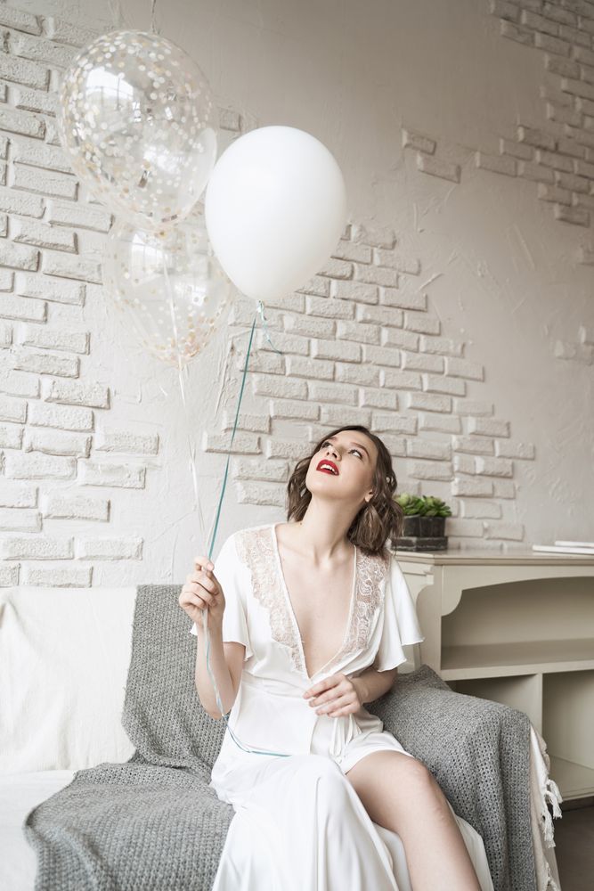 young woman with red lips in white dress smiling at camera
