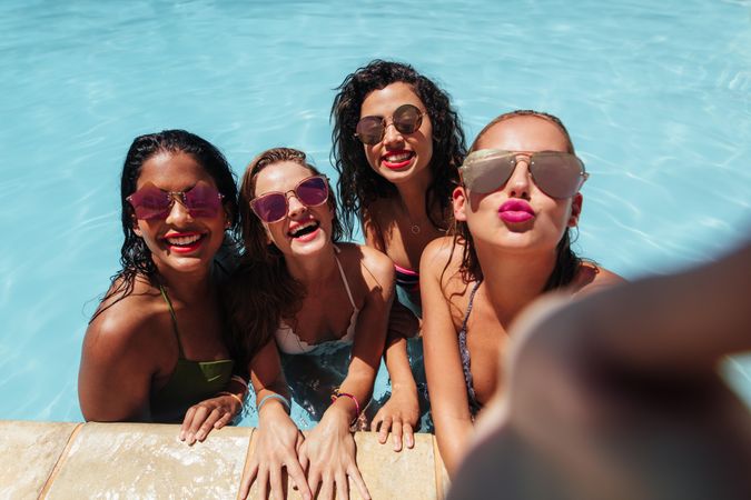 Group of friends wearing stylish sunglasses posing for selfie