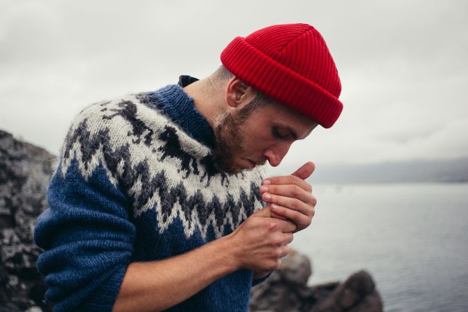 Man lighting cigarette on overcast day