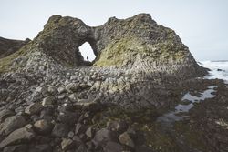 Woman standing inside rocky cave