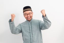 Asian Muslim man smiling doing successful gesture in Ramadan