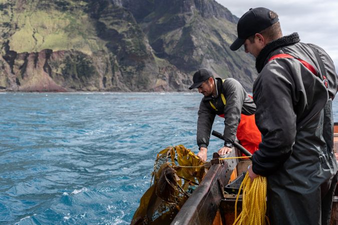 Two fishermen collecting lobster fishing nets