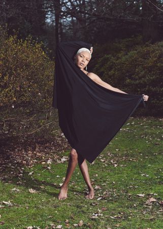 Woman holding dark sheet around body