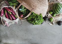 Overhead shot of grocery shopping jute and mesh bags full of fresh produce, copy space