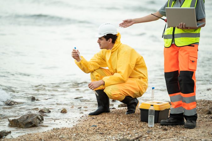 Environment scientist analysing waste water test results and collecting sample for research or inspection of the ecosystem and study of nature from an industrial factory into the sea