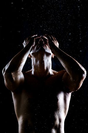 Muscular male under rain