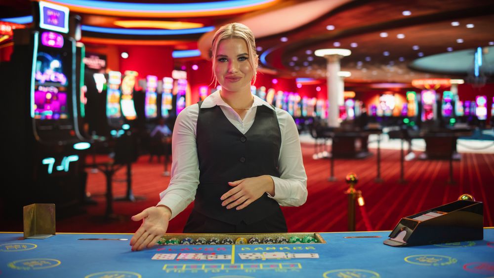 Professional Female Croupier in Casino Dealing Playing Cards on a Baccarat Table.