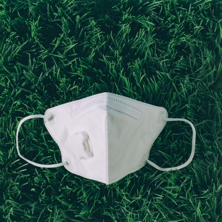 Respiratory or surgical face mask on grass