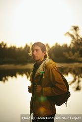 Portrait of a traveler standing beside a lake looking away 0LrGP4