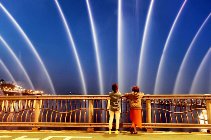 Back view of two people gazing at light show in the sky