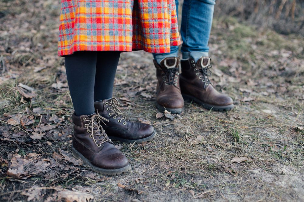 Man and woman in leather boots, jeans and skirt