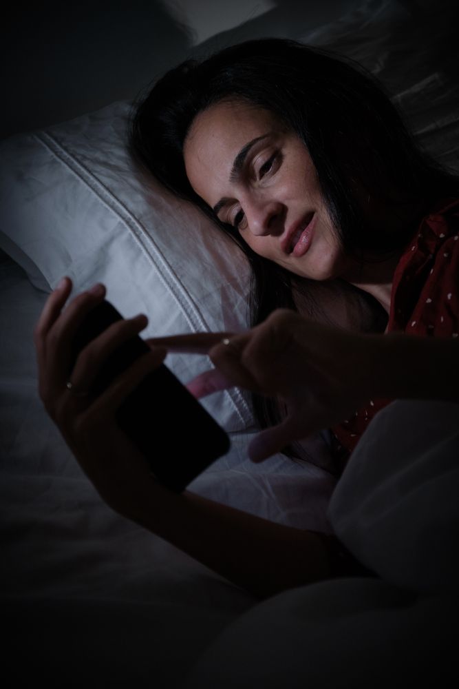 woman browsing smartphone at night time