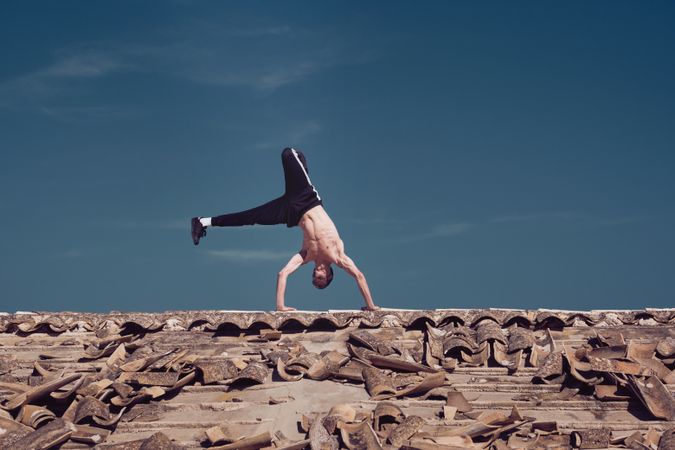 Flexible young man performing two hands rotation while dancing breakdance