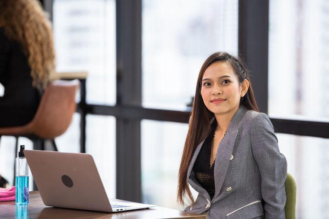 Woman in business attire sitting at her desk in office