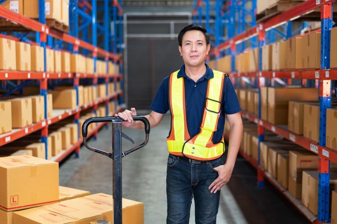 Man working for logistic company with big trolley for boxes