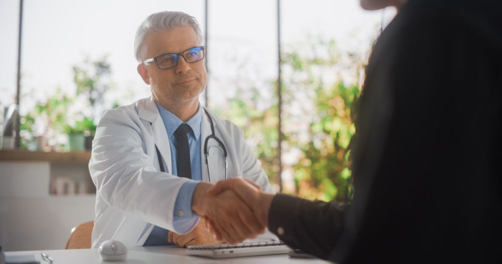 White Doctor Speaking to a Young Man During a Consultation in Health Clinic.