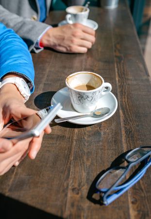 Hands of business woman and man having coffee