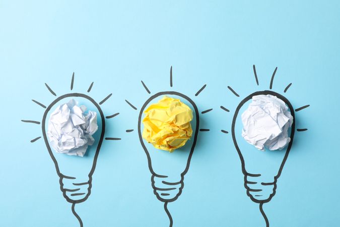 Drawn light bulbs and paper balls on blue background, space for text