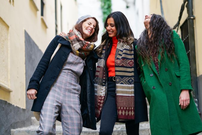 Three female friends dressed in autumn attire together on a walk